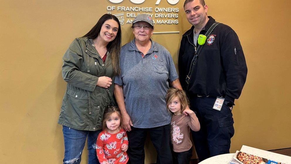 The Klein family pictured with Barbara Gillespie. Barbara is standing between the mother and father, wearing a grey Domino's Pizza shirt.