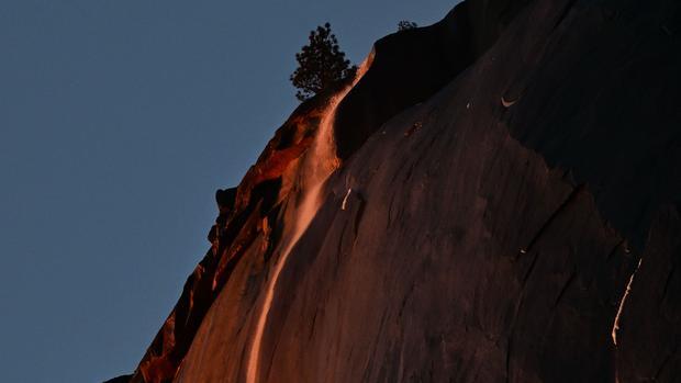Water flowing off Horsetail Fall glows orange while backlit from the setting sun during the "Firefall" phenomenon in Yosemite National Park on Feb. 15, 2023. On rare occasions every year from mid- to late February, the unique lighting effect at Horsetail Falls can be seen when the the sky is clear and water is flowing.